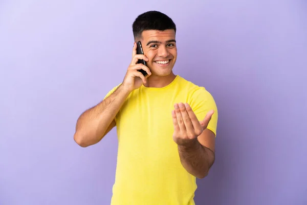 Young Handsome Man Using Mobile Phone Isolated Purple Background Inviting — Stock Photo, Image