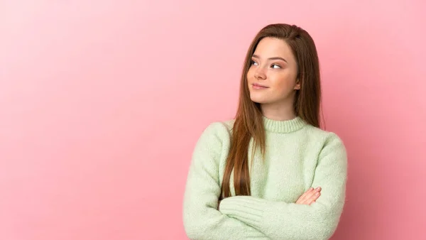 Teenager Dívka Přes Izolované Růžové Pozadí Při Pohledu Strany — Stock fotografie