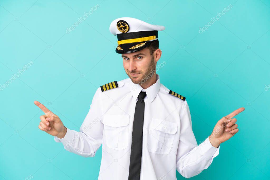 Airplane caucasian pilot isolated on blue background pointing finger to the laterals and happy