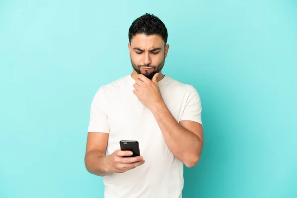 Hombre Árabe Joven Aislado Sobre Fondo Azul Pensando Enviando Mensaje —  Fotos de Stock