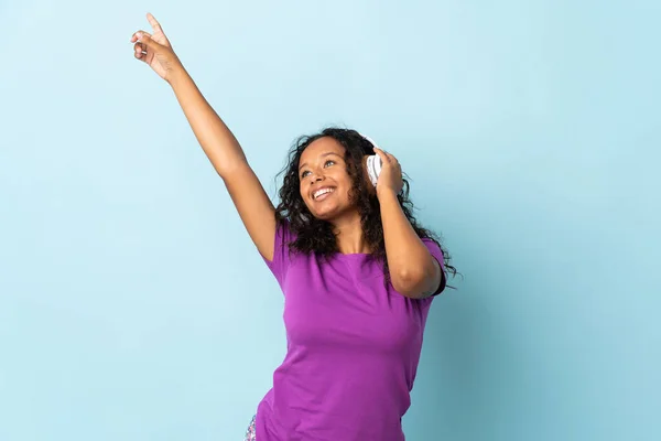 Teenager Cuban Girl Isolated Blue Background Pajamas Holding Pillow Listening — Stock Photo, Image