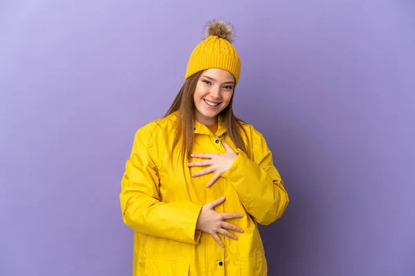 Adolescente Chica Usando Impermeable Abrigo Sobre Aislado Púrpura Fondo Sonriendo —  Fotos de Stock