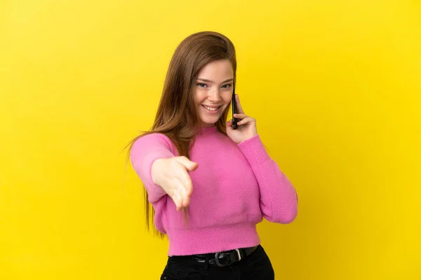 Chica Adolescente Usando Teléfono Móvil Sobre Fondo Amarillo Aislado Estrechando —  Fotos de Stock