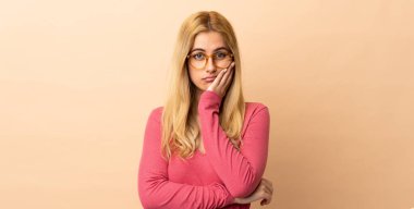 Genç Uruguaylı sarışın kadın izole edilmiş, yorgun ve sıkılmış bir ifadeyle.