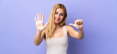 Genç Uruguaylı sarışın kadın tecrit edilmiş arka planda altı parmaklı sayıyor.