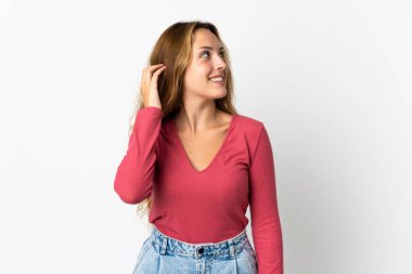 Mavi arka planda izole edilmiş genç sarışın kadın bir fikir düşünüyor.