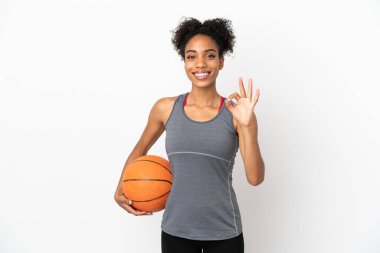 Genç basketbolcu Latin kadın beyaz arka planda izole edilmiş basketbol oynuyor ve 