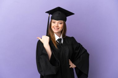 Tecrit edilmiş mor arka planda genç üniversite mezunu bir ürünü sunmak için kenarı işaret ediyor