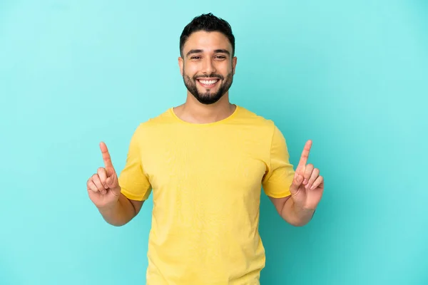 Mladý Arabský Muž Izolovaný Modrém Pozadí Ukazuje Skvělý Nápad — Stock fotografie