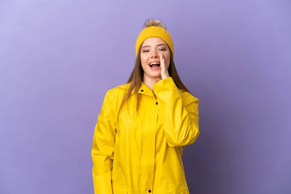 身穿防雨外套的少女在孤立的紫色背景上大喊大叫 张大嘴 — 图库照片