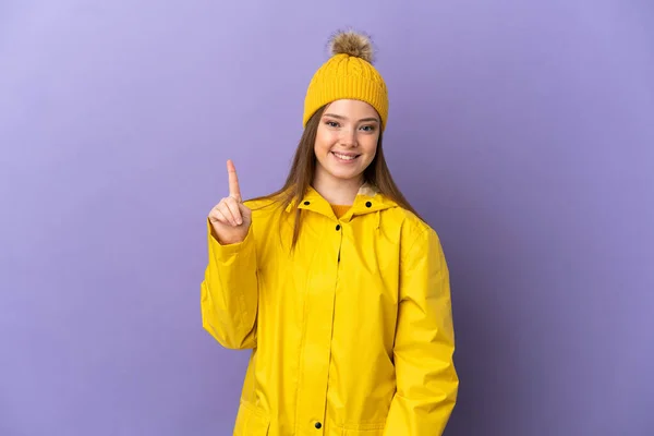 Chica Adolescente Con Abrigo Impermeable Sobre Fondo Púrpura Aislado Mostrando —  Fotos de Stock