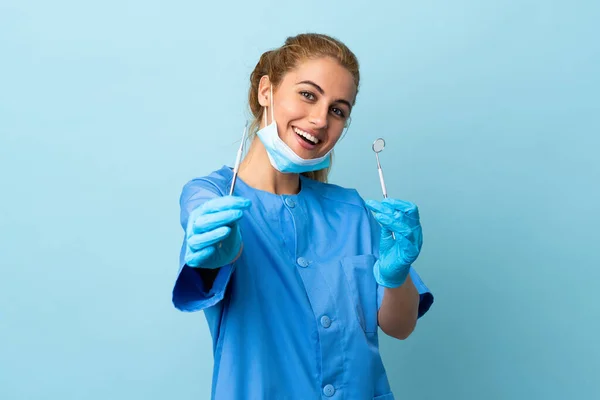 Młoda Kobieta Dentysta Trzyma Narzędzia Odizolowanym Niebieskim Tle — Zdjęcie stockowe