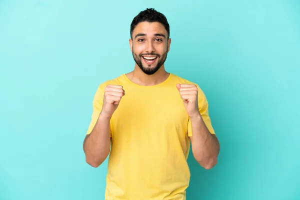 Jeune Homme Arabe Isolé Sur Fond Bleu Célébrant Une Victoire — Photo