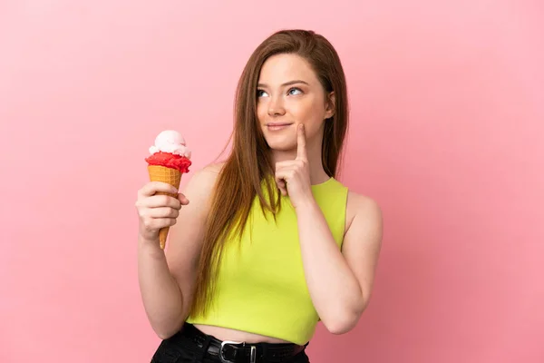 Tiener Meisje Met Een Cornet Ijs Geïsoleerde Roze Achtergrond Denken — Stockfoto
