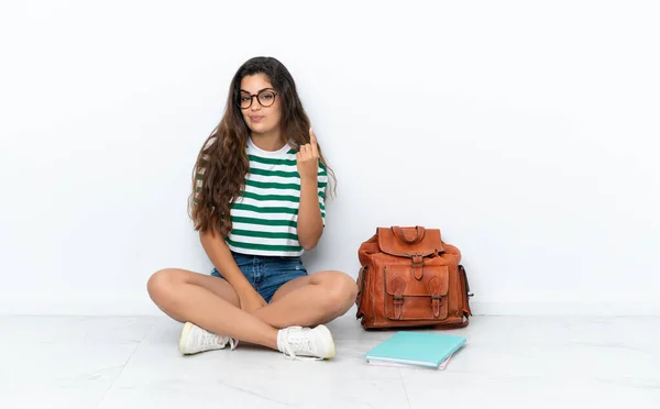 Joven Estudiante Sentada Suelo Aislada Sobre Fondo Blanco Señalando Con —  Fotos de Stock