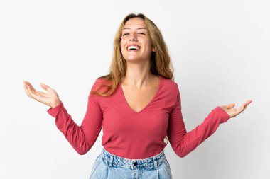 Mavi arka planda izole edilmiş genç sarışın kadın çok gülümsüyor.