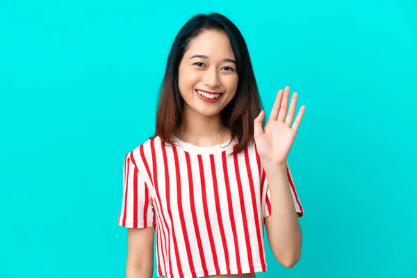Fiatal Vietnami Elszigetelt Kék Háttér Szalutál Kézzel Boldog Kifejezés — Stock Fotó