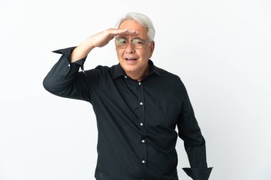 Middle age Brazilian man isolated on white background looking far away with hand to look something