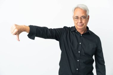 Beyaz arka planda izole edilmiş orta yaşlı Brezilyalı bir adam negatif ifadeyle baş parmağını aşağı gösteriyor.