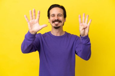 Sarı arka planda izole edilmiş beyaz bir adam dokuz parmaklı sayıyor.