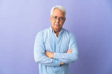 Orta yaşlı Brezilyalı erkek mutsuz bir ifadeyle mor arka planda izole edilmiş.