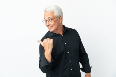 Beyaz arka planda izole edilmiş orta yaşlı Brezilyalı bir adam bir ürün sunmak için kenarı işaret ediyor