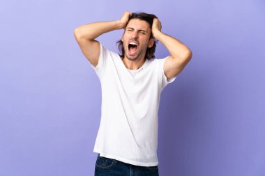 Mor arka planda izole genç yakışıklı adam stresli