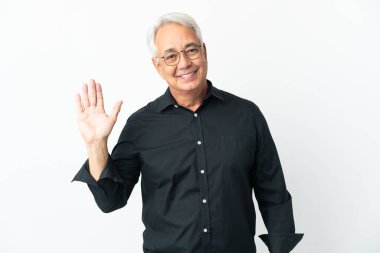 Orta yaşlı Brezilyalı adam beyaz arka planda izole edilmiş mutlu bir ifadeyle selamlıyor.