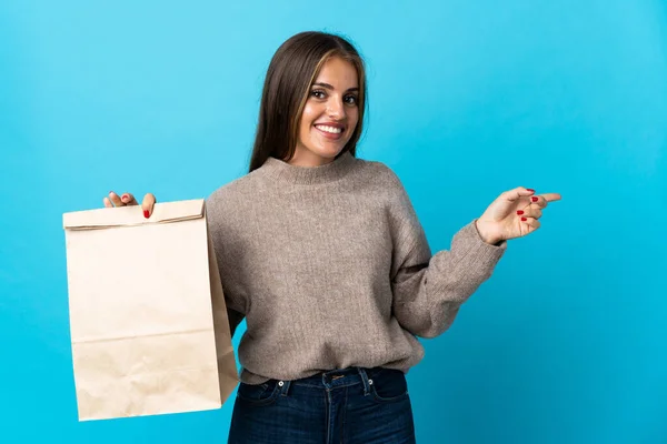 Woman Taking Bag Takeaway Food Isolated Blue Background Pointing Finger — Stock Fotó