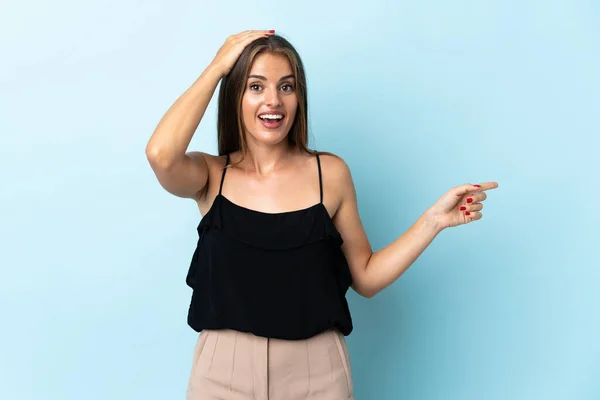 Young Uruguayan Woman Isolated Blue Background Surprised Pointing Finger Side — Stock Fotó