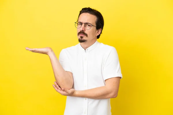 Joven Hombre Caucásico Aislado Sobre Fondo Amarillo Teniendo Dudas — Foto de Stock