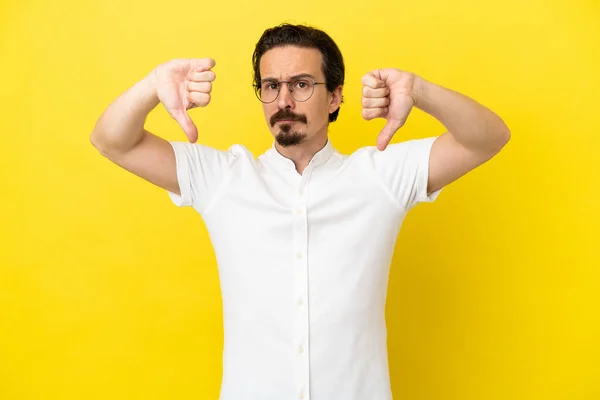 Joven Hombre Caucásico Aislado Sobre Fondo Amarillo Mostrando Pulgar Hacia — Foto de Stock