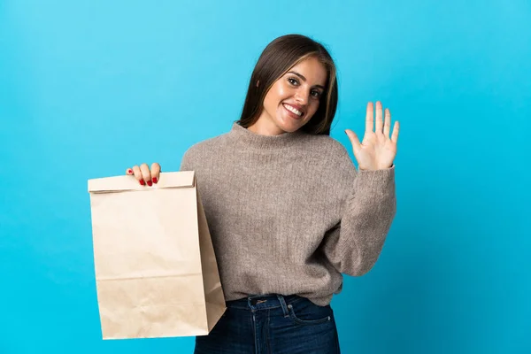 Woman Taking Bag Takeaway Food Isolated Blue Background Saluting Hand — Stock Fotó