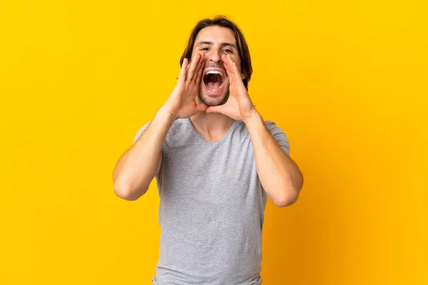 Jovem Bonito Homem Isolado Fundo Amarelo Gritando Anunciando Algo — Fotografia de Stock