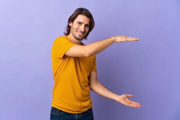 Young Handsome Man Isolated Purple Background Holding Copyspace Insert — Stock Photo, Image