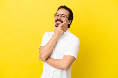 Sarı arka planda izole edilmiş genç beyaz adam mutlu ve gülümsüyor.
