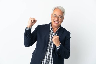 Orta yaşlı Brezilyalı bir adam beyaz bir arkaplanda zaferi kutluyor.