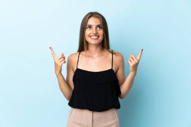 Genç Uruguaylı kadın mavi arka planda izole edilmiş. Harika bir fikre işaret ediyor.