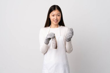 Çinli balıkçı önlük takıyor ve soyutlanmış beyaz arka planda çiğ balık tutuyor para hareketi yapıyor.