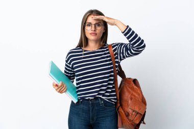 Beyaz arka planda izole edilmiş genç bir kadın. Bir şeye bakmak için elini uzaklara uzatıyor.