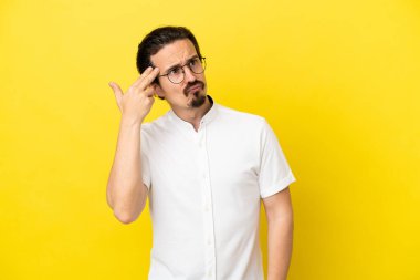 Genç beyaz adam sarı arka planda izole edilmiş ve intihar jesti yapmada sorun yaşıyor.