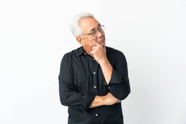 Orta yaşlı Brezilyalı bir adam beyaz arka planda izole edilmiş bir şekilde yukarı bakarken bir fikir düşünüyor.