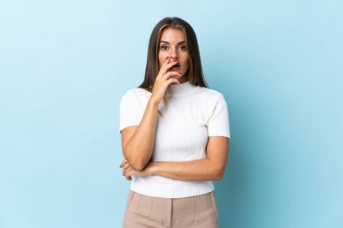 Genç Uruguaylı kadın mavi arka planda izole edilmiş.