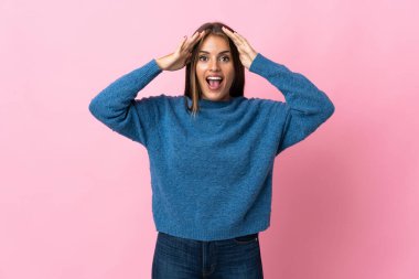 Genç Uruguaylı kadın, pembe arka planda, sürpriz bir ifadeyle izole edilmiş.