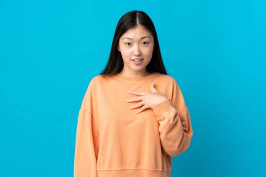 İzole edilmiş mavi geçmişi olan genç bir Çinli kız kendini işaret ediyor.