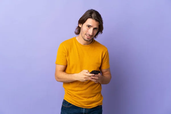 Joven Hombre Guapo Aislado Sobre Fondo Púrpura Enviando Mensaje Con —  Fotos de Stock