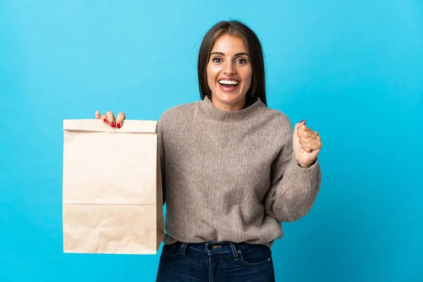 Woman Taking Bag Takeaway Food Isolated Blue Background Celebrating Victory — Stock Fotó