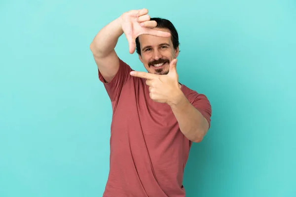 Young Caucasian Man Isolated Blue Background Focusing Face Framing Symbol — Φωτογραφία Αρχείου