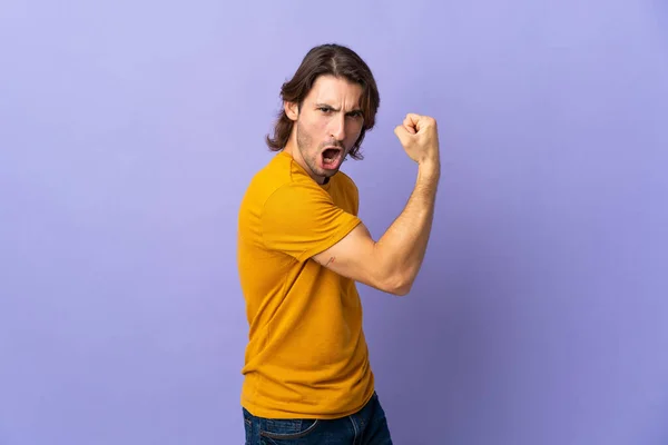 Joven Hombre Guapo Aislado Sobre Fondo Púrpura Haciendo Gesto Fuerte — Foto de Stock