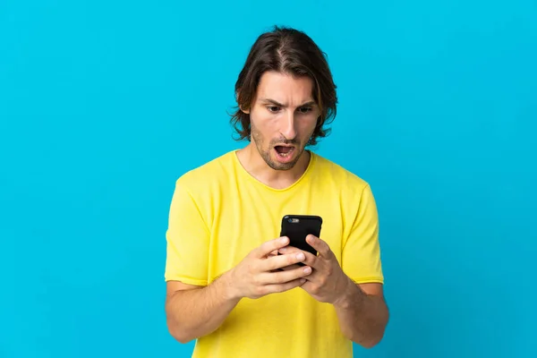 Young Handsome Man Isolated Blue Background Looking Camera While Using — Stock Photo, Image